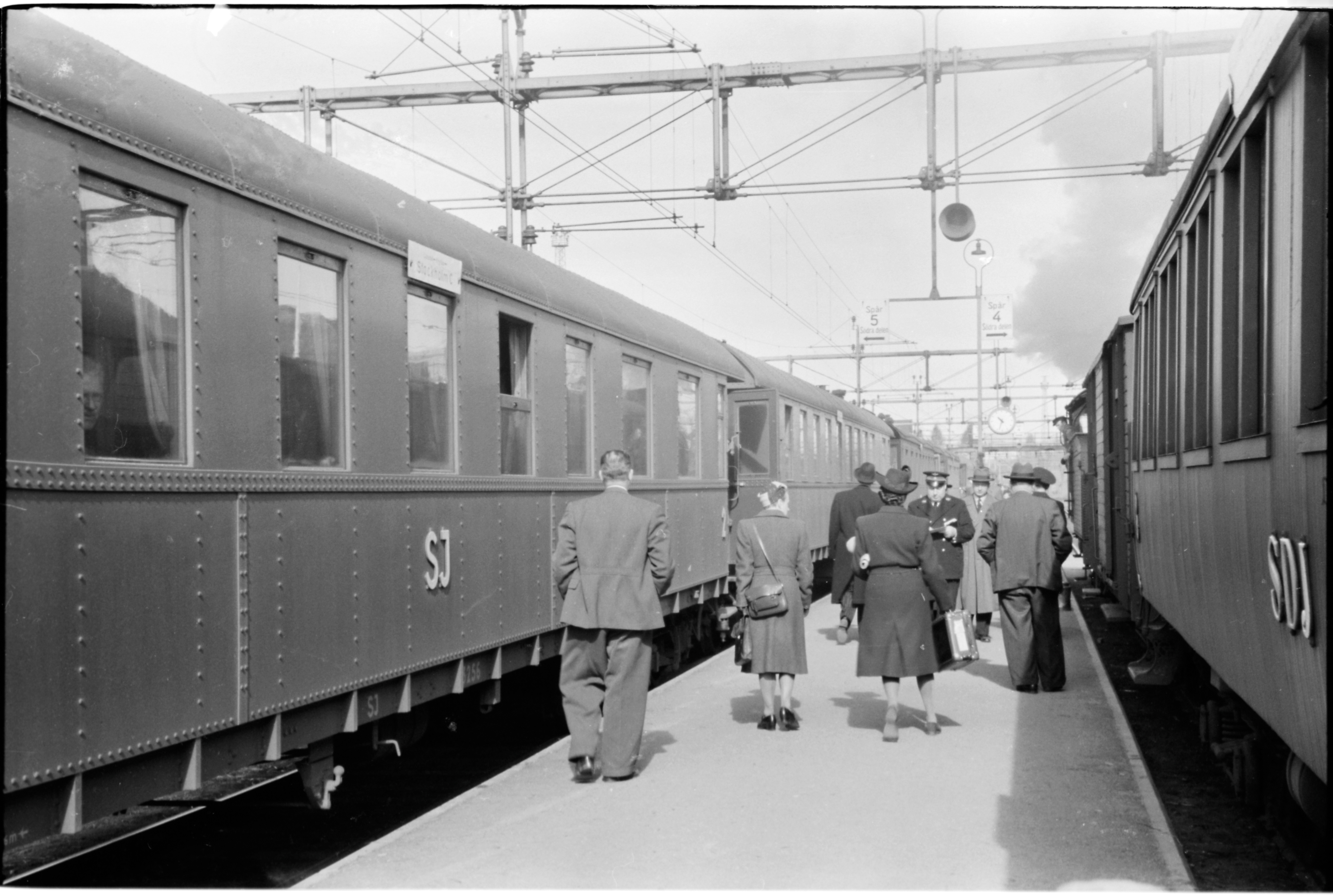 Platform with people between two parked trains.