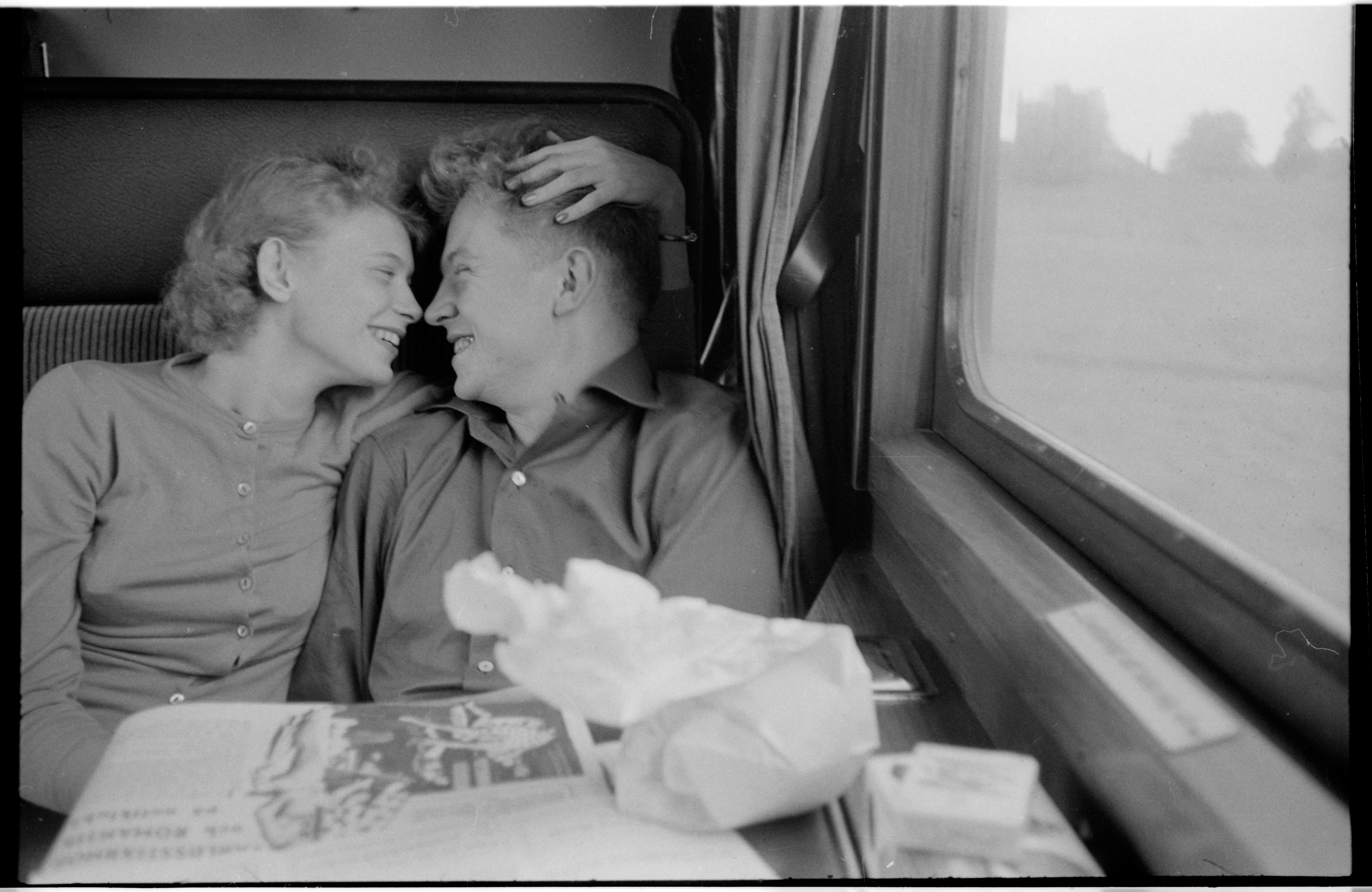 Black and white phot of a couple holding each other in a train