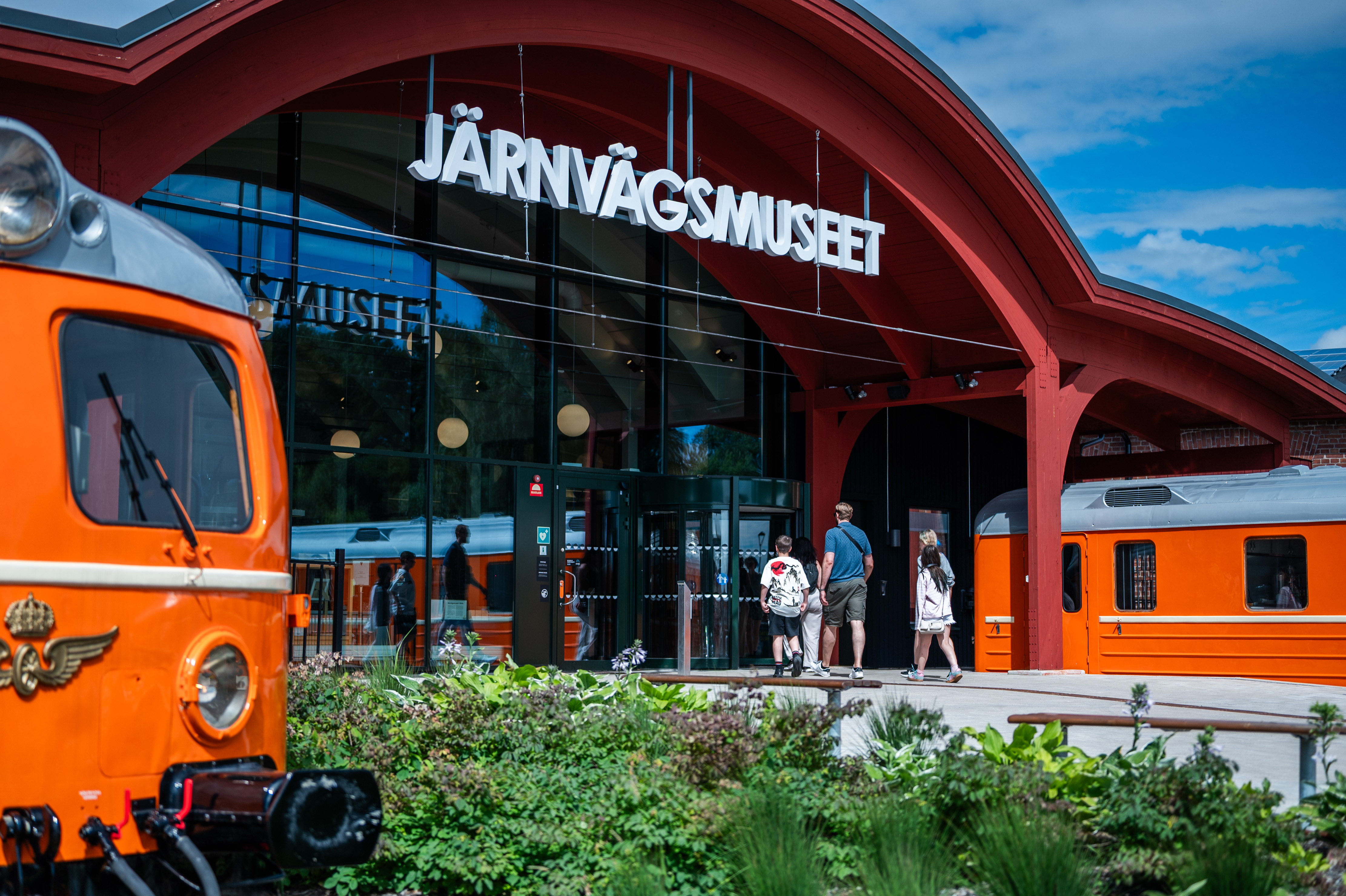En grupp av människor går in genom entrén till Järnvägsmuseet.