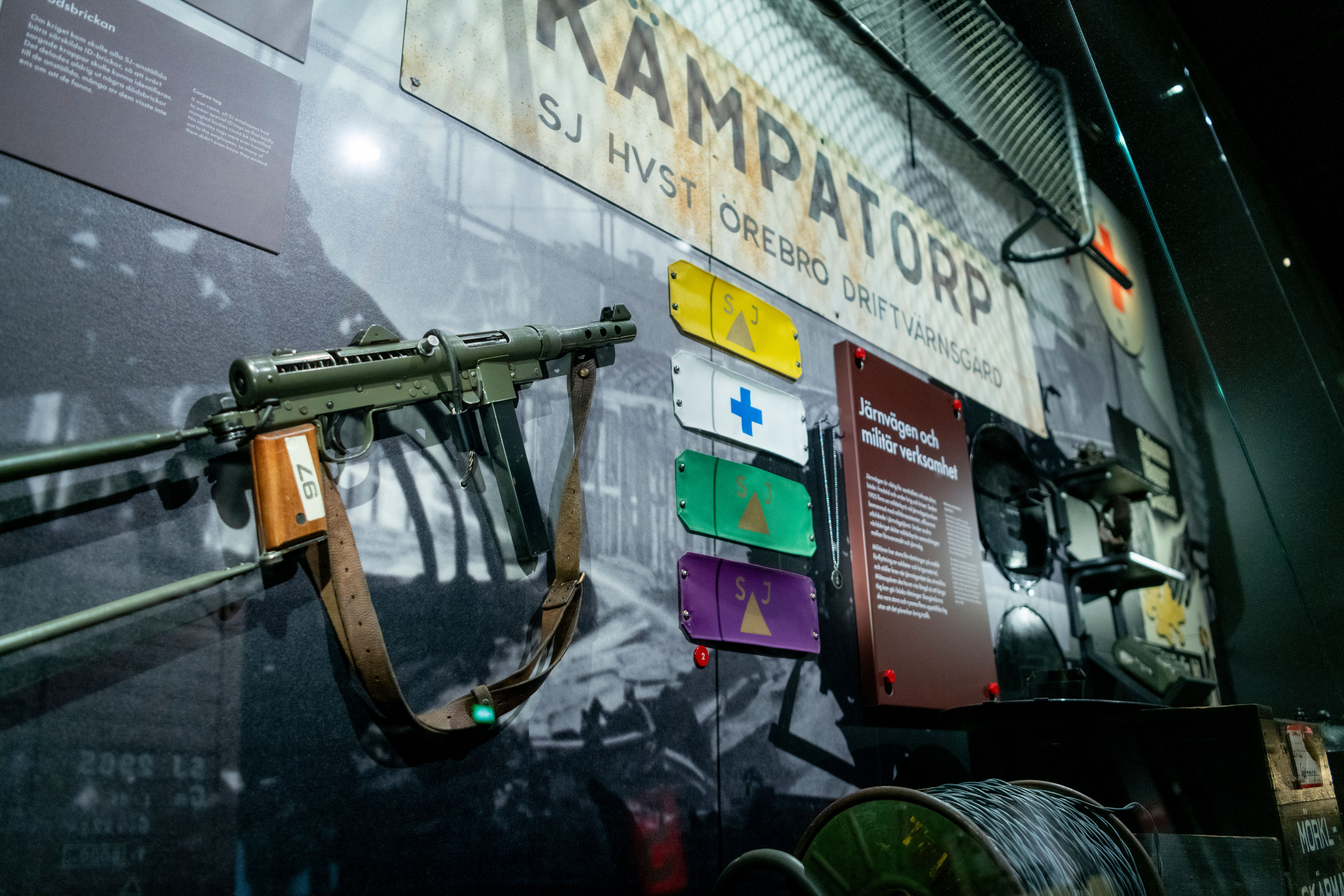 A close up of a green weapon sitting on a wall in an exhibition display.